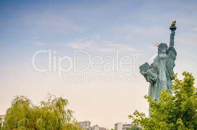 Back view of Statue of Liberty in Paris surrounded by trees