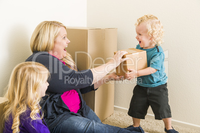 Young Family In Empty Room Playing With Moving Boxes