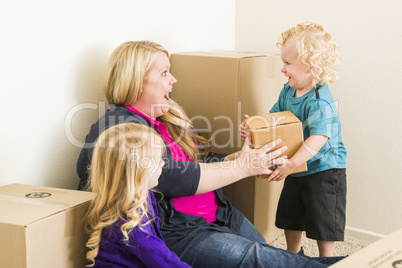 Young Family In Empty Room Playing With Moving Boxes