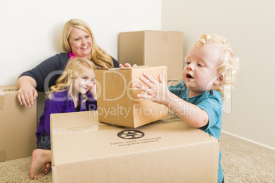 Young Family In Empty Room Playing With Moving Boxes