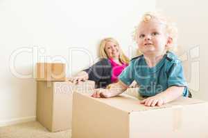 Happy Mother and Son in Empty Room with Moving Boxes