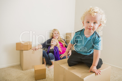 Young Family In Empty Room Playing With Moving Boxes