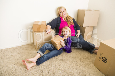 Young Mother and Daughter In Empty Room With Moving Boxes