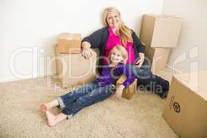 Young Mother and Daughter In Empty Room With Moving Boxes