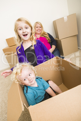 Young Family In Empty Room Playing With Moving Boxes