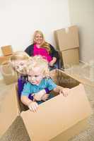 Young Family In Empty Room Playing With Moving Boxes