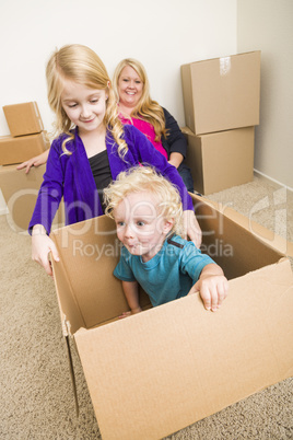 Young Family In Empty Room Playing With Moving Boxes