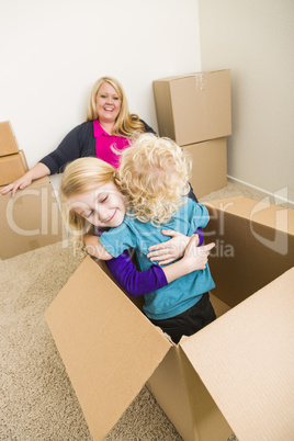 Young Family In Empty Room Playing With Moving Boxes