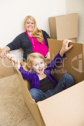 Young Family In Empty Room Playing With Moving Boxes