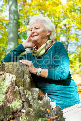 Seniorin enjoys the outdoors in autumn park