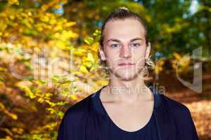 Portrait of a young man in autumn park