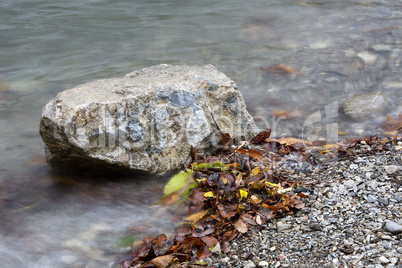 Stone in a lake in autumn with colorful leaves