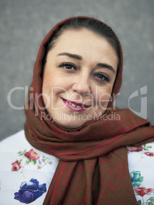 Portrait of the woman close up with a scarf on her head