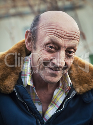 Portrait of a smiling elderly man outdoors closeup