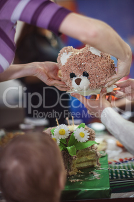 Little boy and his birthday cake in the shape of bears