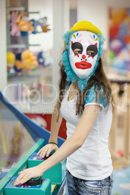 Girl in a mask of a clown at children's parties