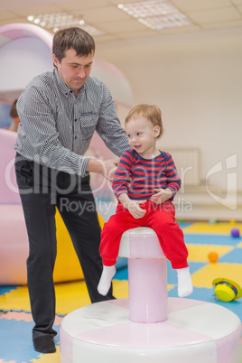 Dad and his little son playing on children's holiday