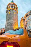 Taksi under Galata Tower at dusk. Vintage street scene in Istanb