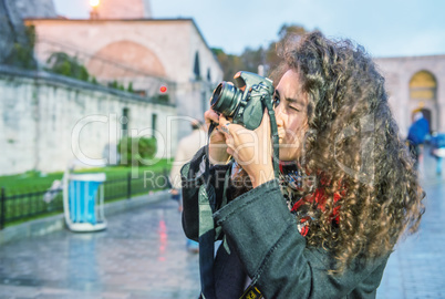 Tourist woman photographing Hagia Sophia at dusk, Istanbul