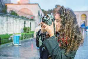 Tourist woman photographing Hagia Sophia at dusk, Istanbul