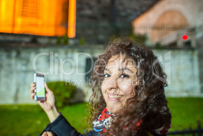 Tourist female with mobile phone in Istanbul, night scene in Sul