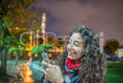 Beautiful tourist female with her smartphone enjoying Blue Mosqu