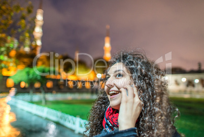 Beautiful tourist woman speaking at the phone in the night of Is Beautiful tourist woman speaking at the phone in the night of Is