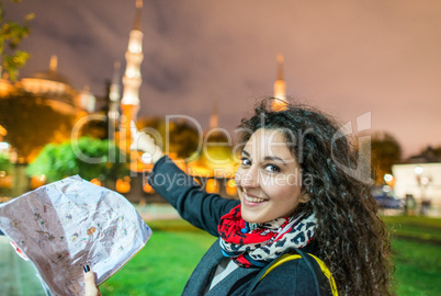 Beautiful happy female tourist with city map enjoying view of Bl