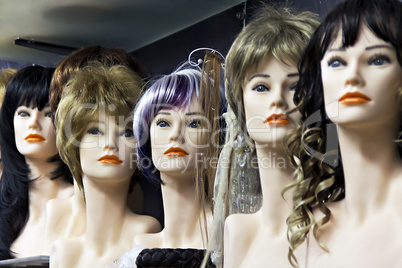 Several female mannequins with wigs