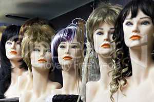 Several female mannequins with wigs