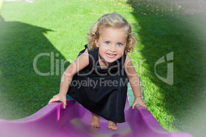 kleines Mädchen Leni Louisa will eine lila Rutsche hochklettern