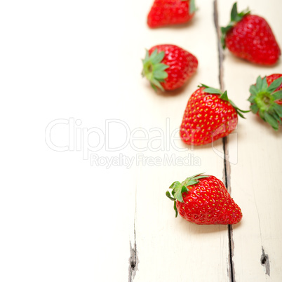 fresh organic strawberry over white wood