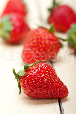 fresh organic strawberry over white wood