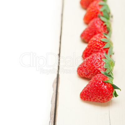 fresh organic strawberry over white wood