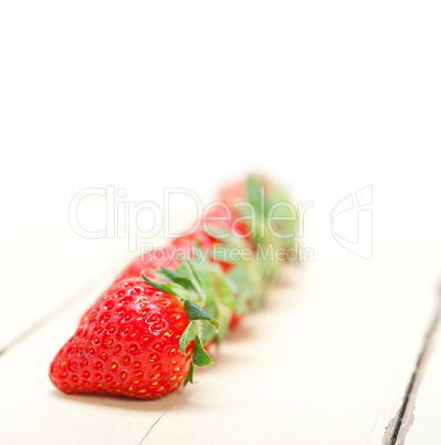 fresh organic strawberry over white wood