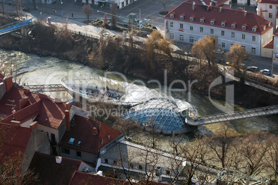 Island on Mur river connected by a modern steel and glass bridge