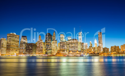 Stunning Manhattan lights at dusk. Reflections on East River - N