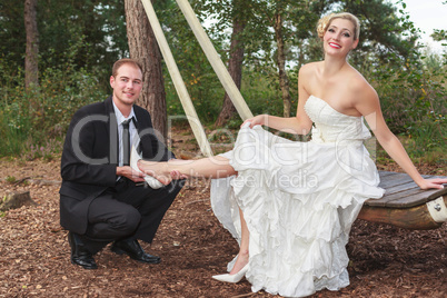 Bräutigam zieht seiner Braut die Schuhe an.