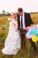 Lustiges Hochzeitspaar mit Luftballons