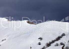 Off piste slope and overcast gray sky in windy day