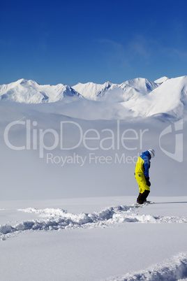 Snowboarder on off-piste slope with new fallen snow