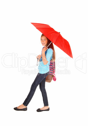 Young girl walking with umbrella.