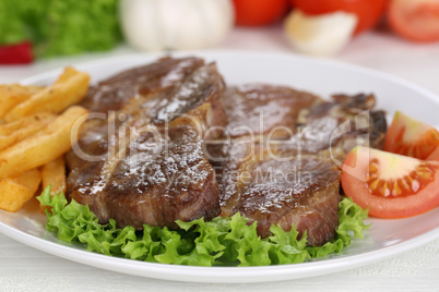 Steaks vom Schwein Fleisch Gericht mit Pommes, Gemüse und Salat