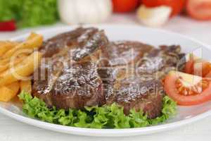 Steaks vom Schwein Fleisch Gericht mit Pommes, Gemüse und Salat