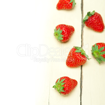 fresh organic strawberry over white wood