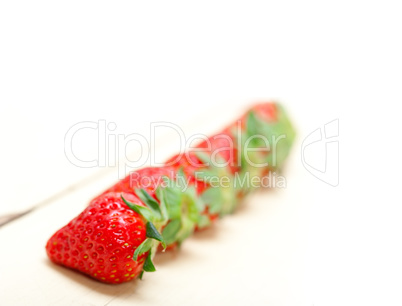 fresh organic strawberry over white wood