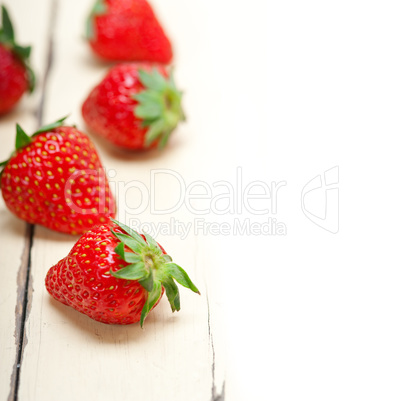 fresh organic strawberry over white wood