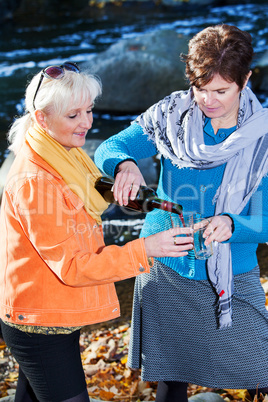 Two women enjoying leisure time on the river with wine