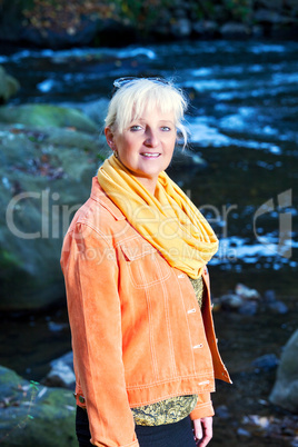 Woman alone in autumn atmosphere at the river