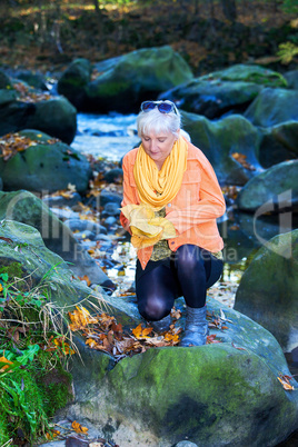 Woman alone in autumn atmosphere at the river